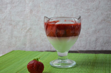 Italian dessert panna cotta with fresh strawberries or yogurt or pudding on a green napkin