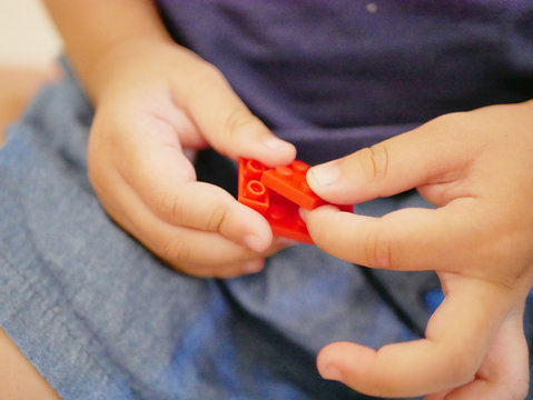 Interlocking Plastic Bricks (toy) In Baby's Hands - Playing Interlocking Bricks Provides Opportunity For Building Fine Motor Skill And Sense Of Acchievement In Babies