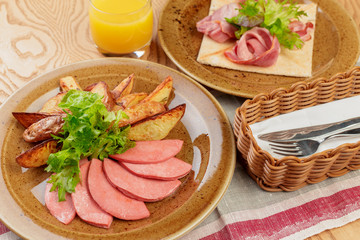 Roasted potatoes with ham slices close up