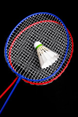 Badminton racket and shuttlecock on black background