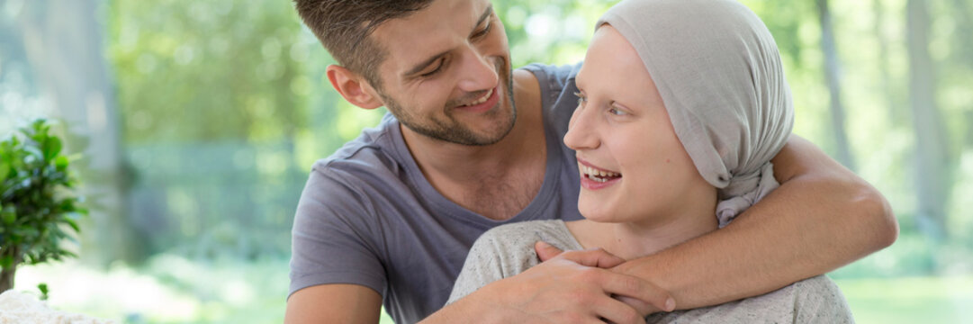 Panorama of happy man hugging smiling sick wife after chemotherapy