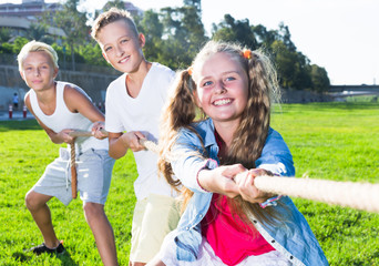 Children pulling rope outdoors