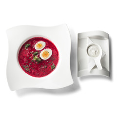 Cold soup Svekolnik and a spoon, isolated on white background, view from above