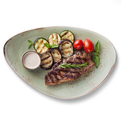 Steak with grilled vegetables, isolated on white background, view from above