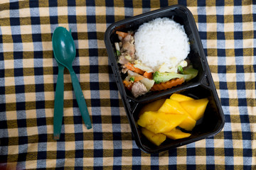 Rice and vegetables served with mango in lunch box