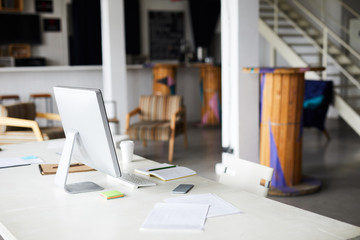 Workplace of office manager or designer with computer monitor, keypad, notebook, papers and smartphone