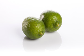two fresh green lime isolated white