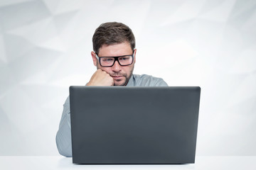 Bearded man with glasses working on laptop Look at the screen.