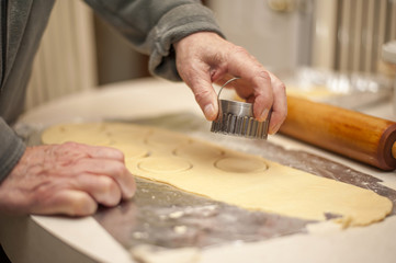 Baker prepares dough cut outs with cookie cutter