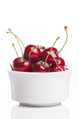 fresh red cherry on the white ceramic isolated white