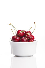 fresh red cherry on the white ceramic isolated white