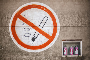Big sign on concrete wall with no smoking sign