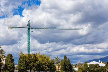 Construction crane against the sky on the Spanish coast. Andalusia. Costa del Sol.