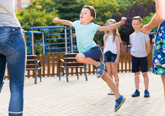 Obraz premium Happy children skipping on jumping elastic rope