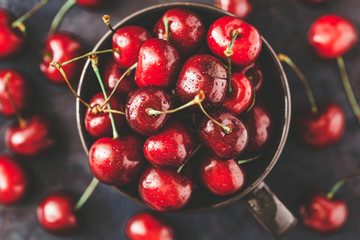 Top view of a bowl with ripe cherry over blue background. The concept of healthy organic food.