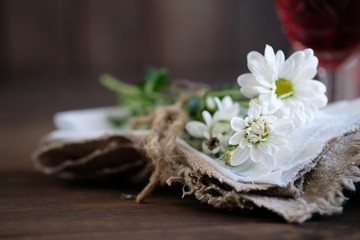 Fototapeta na wymiar chamomiles in napkin on old rustic wooden table