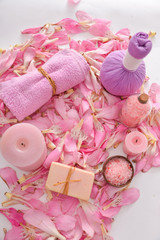 Obraz na płótnie Canvas Many pink tropical petals and candle ,soap ,herbal ball,towel , ,salt in bowl ,candle