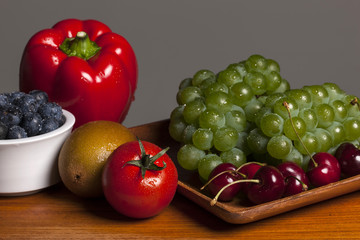 many variety fruits on the wood table, grey background