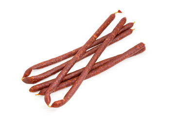 Cured and smoked thin sausages on a white background