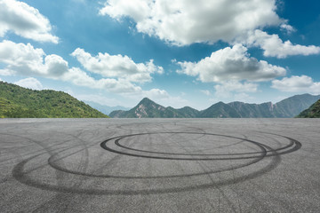 Empty asphalt square and mountain scenery under the blue sky