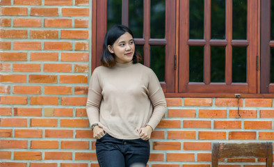 Young asian girl standing on the brick wall background
