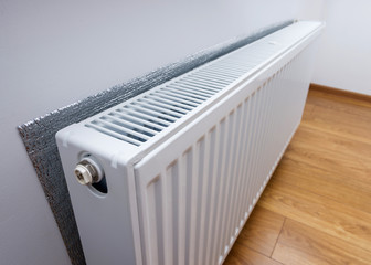 White metal heating radiator forming part of a central heating system with energy-efficient thermal...