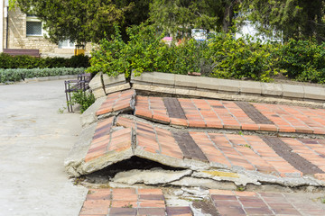 Broken Pavement of tiles in a public Park.