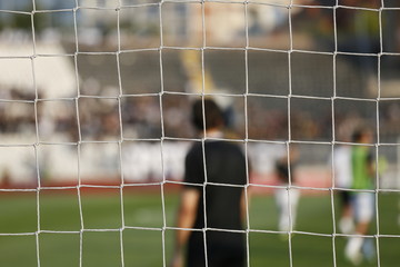 fubal goal net during the game. selective focus. football players in blur