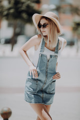 Portrait of young pretty trendy girl posing at the city in Europe, summer street fashion.