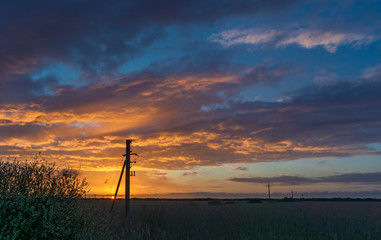 Sunrise with power masts in the foreground