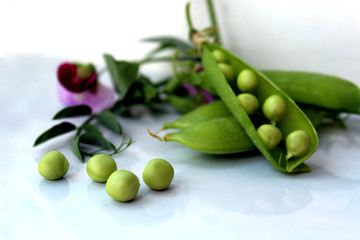 fresh crop of green peas with a flower