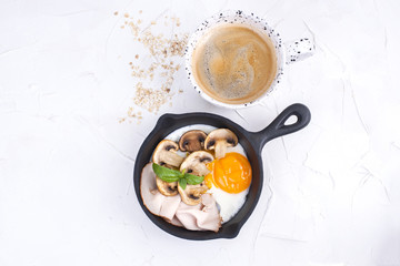 Delicious healthy breakfast. Fried eggs with bacon and mushrooms in a small frying pan. Top view. Copy space,