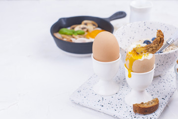 A delicious continental breakfast for the whole family, oatmeal, coffee, eggs, berries and milk. Top view. Copy space,