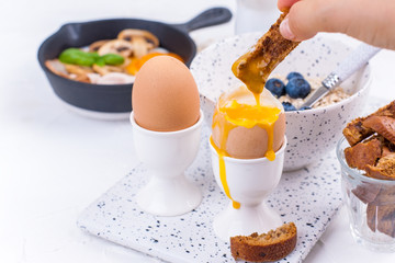 A delicious continental breakfast for the whole family, oatmeal, coffee, eggs, berries and milk. Top view. Copy space.