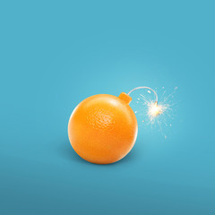 Concept of an orange bomb. Creative bomb with sparks. Juicy Orange