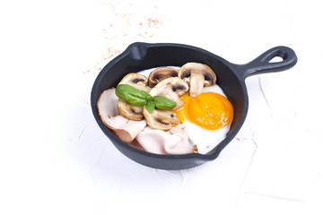 Delicious healthy breakfast. Fried eggs with bacon and mushrooms in a small frying pan. Top view. Copy space,