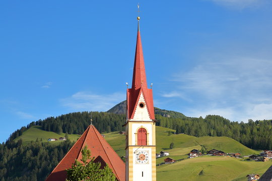 The Maria Hilf parish church of Selva with green meadows in the background, Val Gardena, Dolomites, Italy