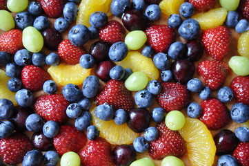 Obraz premium Obstkuchen mit Blaubeeren, Kirschen, Erdbeeren und Mandarinen