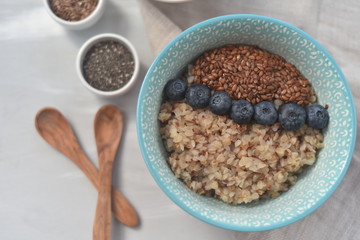 Buckwheat porridge in a bowl with flax seeds and blueberries. oncept healthy food, detox, diet, breakfast