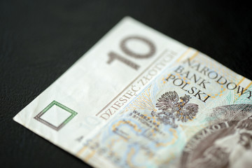 A banknote in ten Polish zlotys against a dark background close up