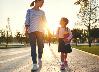 first day at school. mother leads  little child school girl in first grade.