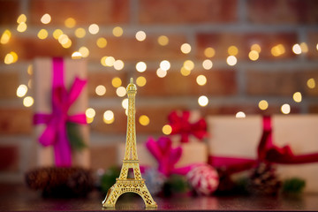 golden eiffel tower souvenir on background with fairy lights in bokeh. Christmas Holiday season