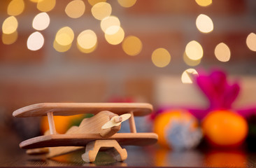 wooden airplane toy on background with fairy lights in bokeh. Christmas Holiday season