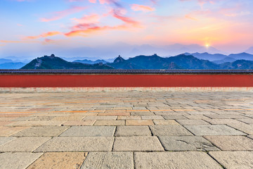 Square brick floor and and great wall with mountains at sunset