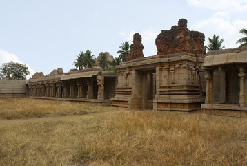 Carved pillars of the inner courtyard, cloisters or pillared verandah and the east gopura. Achyuta Raya temple, Hampi, Karnataka. Sacred Center. View from the west side.