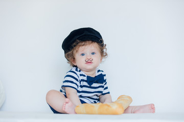 Little baby with mustache, beret and baguette on white background.