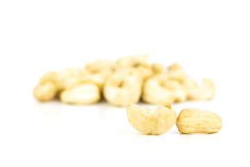Lot of whole raw cashew nut two in focus isolated on white background