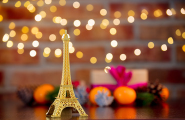 golden eiffel tower souvenir on background with fairy lights in bokeh. Christmas Holiday season
