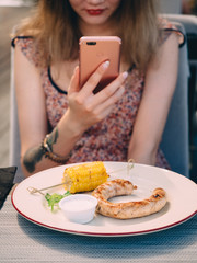Young pretty girl in cafe taking photo of food