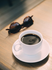 Cup of black espresso coffee at wooden table in cafe
